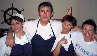 Four people wearing aprons and smiling. Description generated by AI