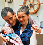 A man and woman holding a baby. Description generated by AI