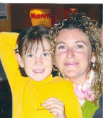 A woman and a girl are posing for a picture. Description generated by AI