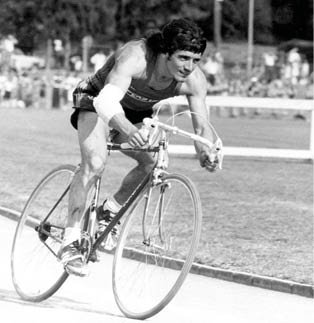 A man riding a bike on a track. Description generated by AI
