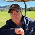 A man wearing a blue jacket is sitting in a golf cart. AI generated content