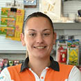 A woman is smiling and holding a card reader at a counter. AI generated content