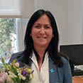 A woman in a blue jacket is holding a bouquet of flowers. AI generated content