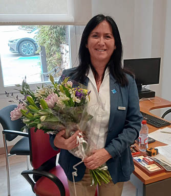 A woman in a blue jacket is holding a bouquet of flowers. AI generated content
