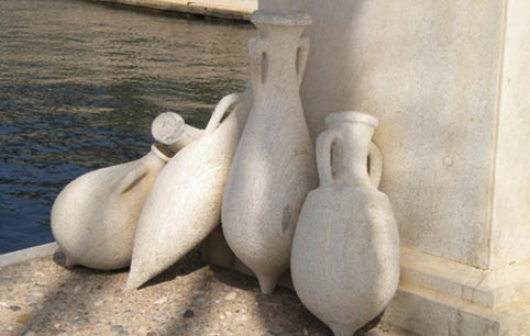 Three white vases on the ground. Description generated by AI