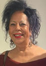 A woman with black hair and a red lipstick smile. Description generated by AI