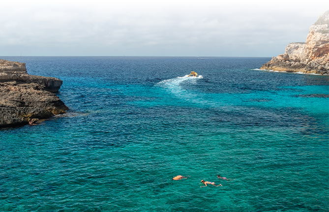 A group of people swimming in the ocean. Description generated by AI