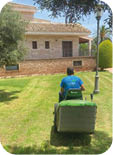 A man is sitting on a green lawn mower. Description generated by AI