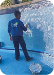 A man is painting a pool with a spray gun. Description generated by AI