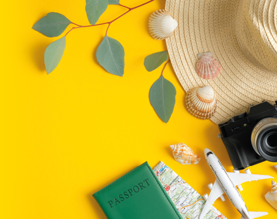 Summer travel accessories on yellow background  Flat lay beach hat, vintage camera, plane, map, passport, seashells and green leaves  Holiday trip planning concept